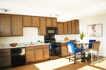 A kitchen with wooden cabinets and a black stove top oven.